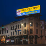 An Epoch Times billboard over a building at Lake Street and 2nd Ave. On the other side is protest banners reading "Stop the genocide in Gaza".