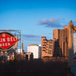A Grain Belt Beer sign on the shores of the Mississippi River and the Hennepin Avenue Bridge. March 2024.
