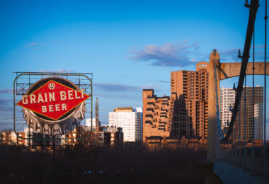 A Grain Belt Beer sign on the shores of the Mississippi River and the Hennepin Avenue Bridge. March 2024.