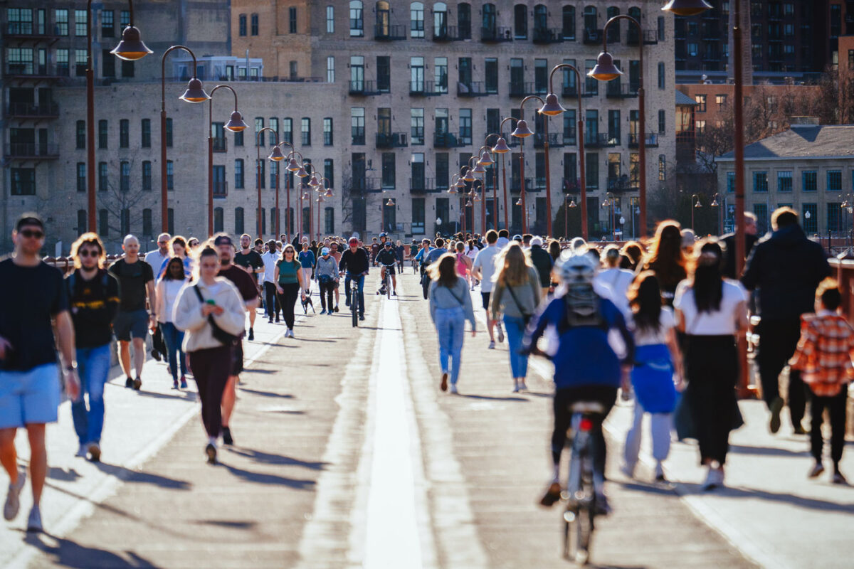 People walking jogging biking on bridge