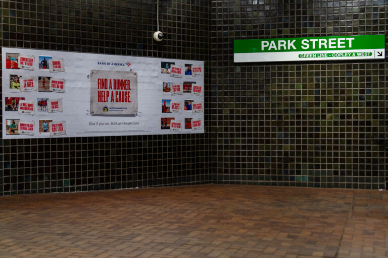 Boston Marathon and Park Street Station, Boston 1 Inside Boston’s Park Street Station, a tiled corridor displays a Bank of America advertisement for the Boston Marathon’s charity initiative. The green and white MBTA sign directs riders toward the Green Line platforms for Copley and westbound service. Park Street—one of the oldest subway stations in the United States—sits beneath the Boston Common, serving as a major interchange for the city’s transit system since 1897.