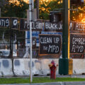 Signs hang on the fencing around the Minneapolis Police 3rd Precinct police station. The station burned 4 years ago on this day.