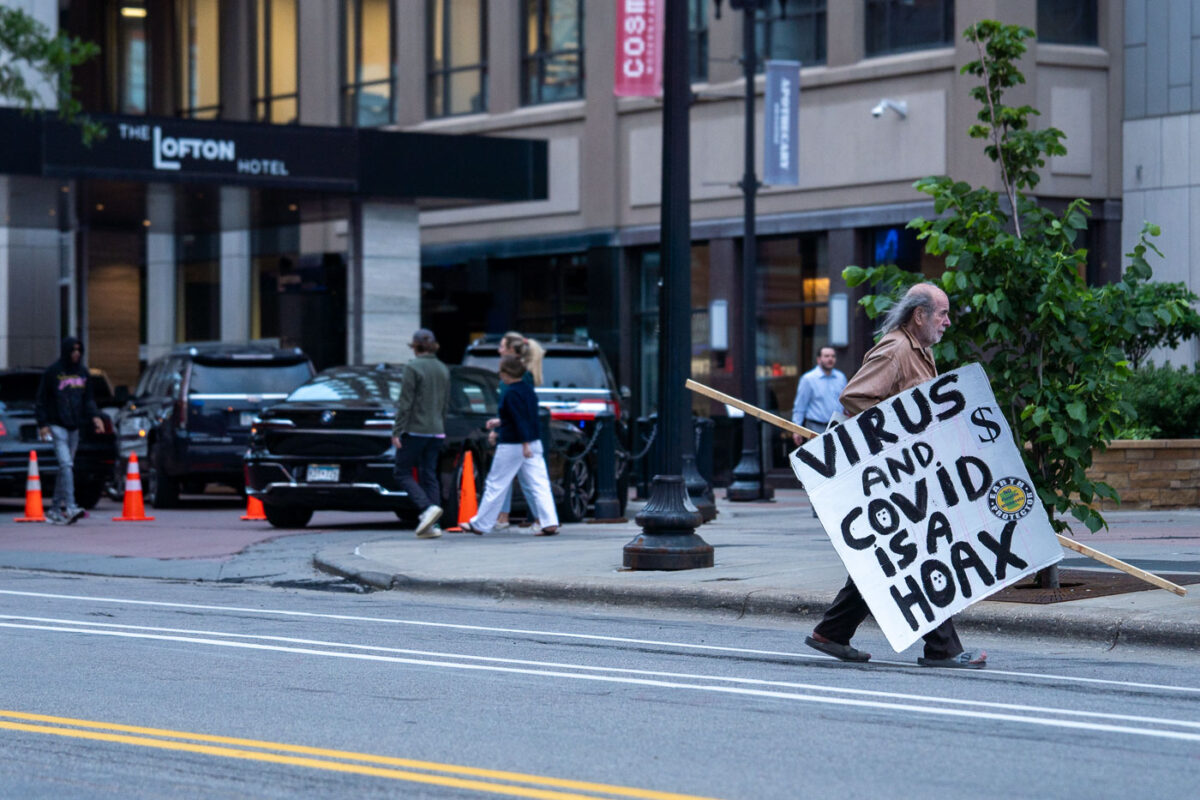 A man with a anti covid virus sign in downtown Minneapolis in May 2024.