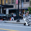A man with a anti covid virus sign in downtown Minneapolis in May 2024.