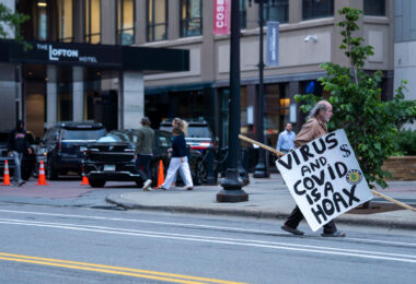 A man with a anti covid virus sign in downtown Minneapolis in May 2024.