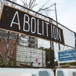Signs hang on the former Minneapolis Police 3rd precinct police station on June 19th, 2024. The station has sat vacant since it was burned by protesters following the May 25th, 2020 murder of George Floyd.