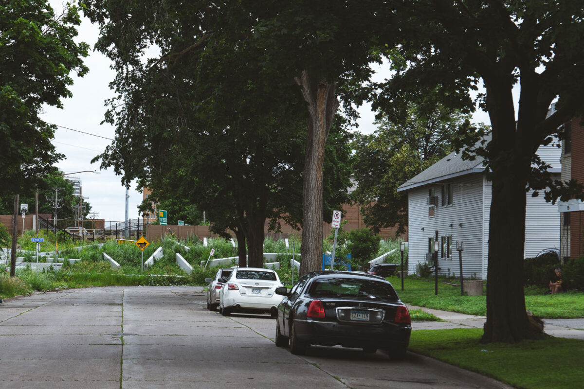 Concrete barricades in the grass in South Minneapolis. Officials began filling empty lots that encampments previously occupied with rubble from the city. Concrete chunks and street poles have been used in other locations.