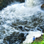 A man fishes at the bottom of Minnehaha Falls in Minneapolis.