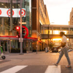 A scooter and a man walks on Nicollet Mall during a June 2024 sunset.