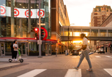 A scooter and a man walks on Nicollet Mall during a June 2024 sunset.