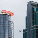 A Sun Country Airlines plane flies above downtown Minneapolis.