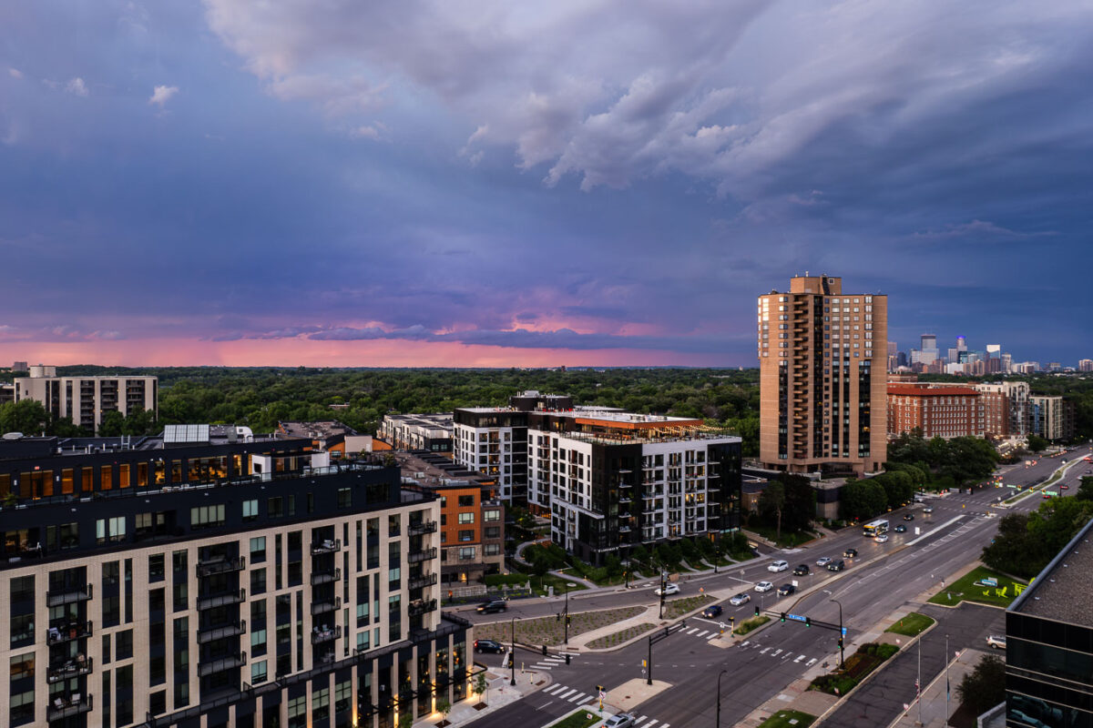 Lake Street and Excelsior Blvd near the western edge of Minneapolis during a June sunset. Waterbury House on the left where rent ranges from $2,495 to $12,995 a month. The apartment building on the triangle lot replaced a long standing BP gas station.