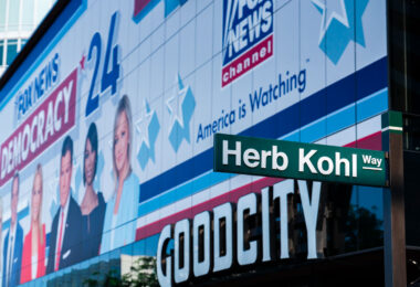 Fox News banner behind a Herb Kohl Way sign outside Fiserv Forum.