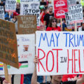 Protester holds up a sign that reads "May Trump Rot in Hell" at a march outside the 2024 Republican National Convention.