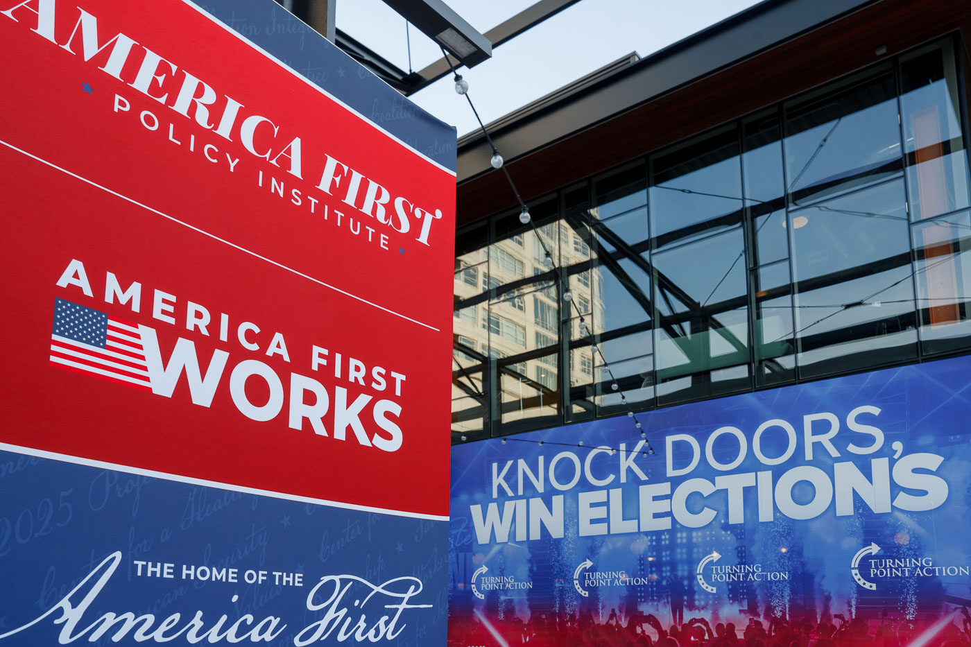 America First Policy Institute and Turning Point Action banners outside the Fiserv Forum in Milwaukee, the site of the 2024 Republican National Convention.