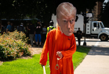 A man dressed as Donald Trump in jail uniform with handcuffs outside the Republican National Convention.