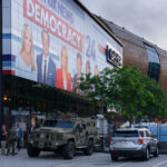 Security fencing and vehicles at an entrance to the hard security zone at Fiserv Forum during the 2024 Republican National Convention.
