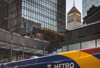 The Foshay Tower and IDS Center in Downtown Minneapolis with a Metro Transit bus passing.