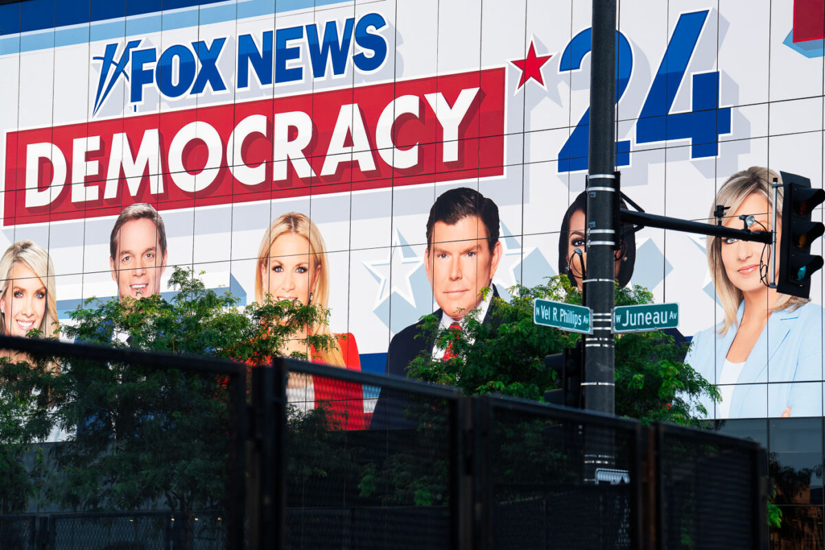 Large Fox News billboard on the side of a building outside the 2024 Republican National Convention. Security fencing visible in the foreground.