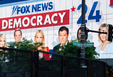 Large Fox News billboard on the side of a building outside the 2024 Republican National Convention. Security fencing visible in the foreground.