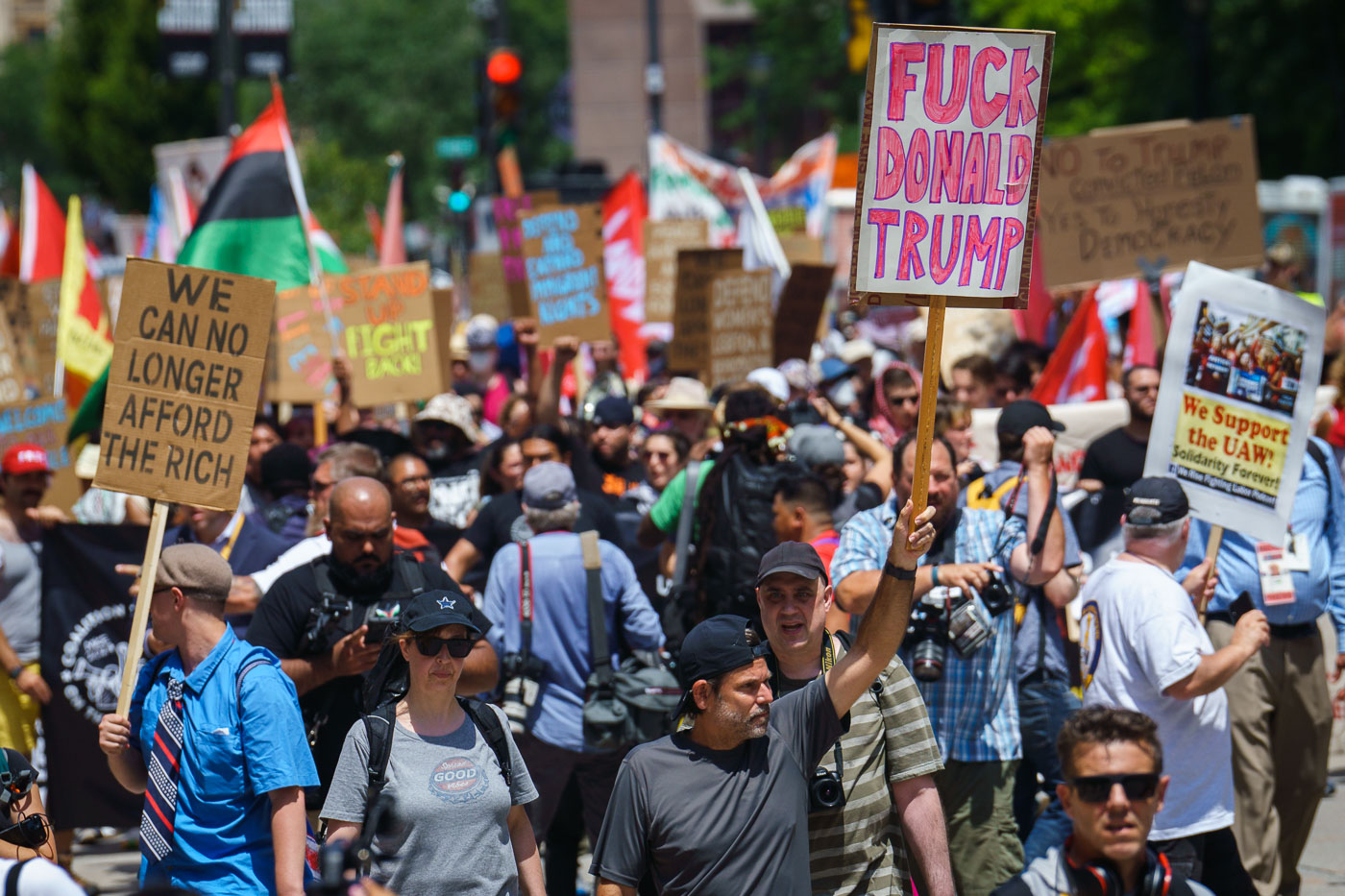 A man holds up a "Fuck Donald Trump" protest sign at a march outside the 2024 Republican National Convention.