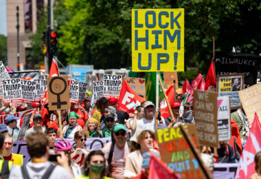 Protester holds up a sign reading "Lock Him Up!" at a march around the 2024 Republican National Convention in Milwaukee.