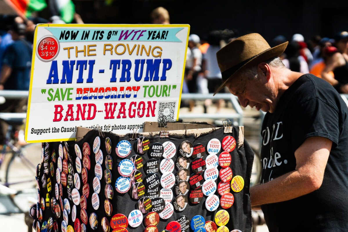 A man sells pins from his cart that he calls The Roving Anti-Trump "Save Democracy Tour!" Band-Wagon outside the Republican National Convention.