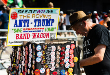 A man sells pins from his cart that he calls The Roving Anti-Trump "Save Democracy Tour!" Band-Wagon outside the Republican National Convention.