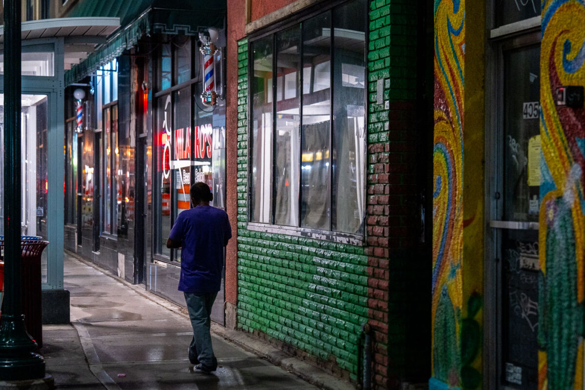 A man walking on the sidewalk down Lake Street in South Minneapolis.