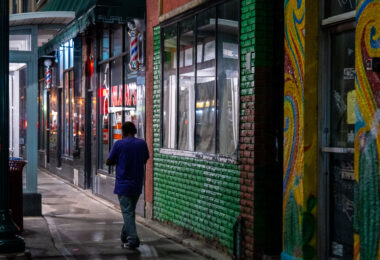 A man walking on the sidewalk down Lake Street in South Minneapolis.