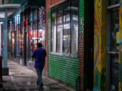 Man walks down Lake Street, Minneapolis at night