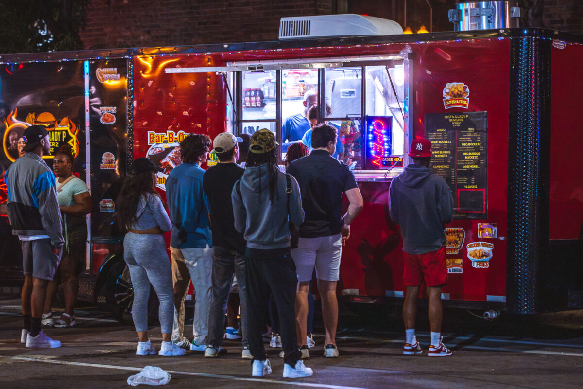 People stand in line at a food truck at Warehouse District Live in Minneapolis.