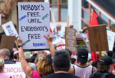 Protester holding up a sign that reads "Nobody's Free Until Everybody's Free" at a march during the 2024 Republican National Convention.