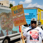 Anthony Johnson holds up a sign that reads "Fight the racist and reactionary republican agenda" outside the 2024 Republican National Convention in Milwaukee.