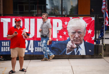 RNC 2024 Trump Supporter on megaphone outside a Republican National Convention checkpoint.