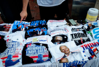 A T-shirt vendor at the Republican National Convention. Pointing to what he says is his best selling shirt, one of after Trump was shot.