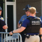 A Secret Service officer speaks to local law enforcement officers at the secure perimeter of the 2024 Republican National Convention in Milwaukee.
