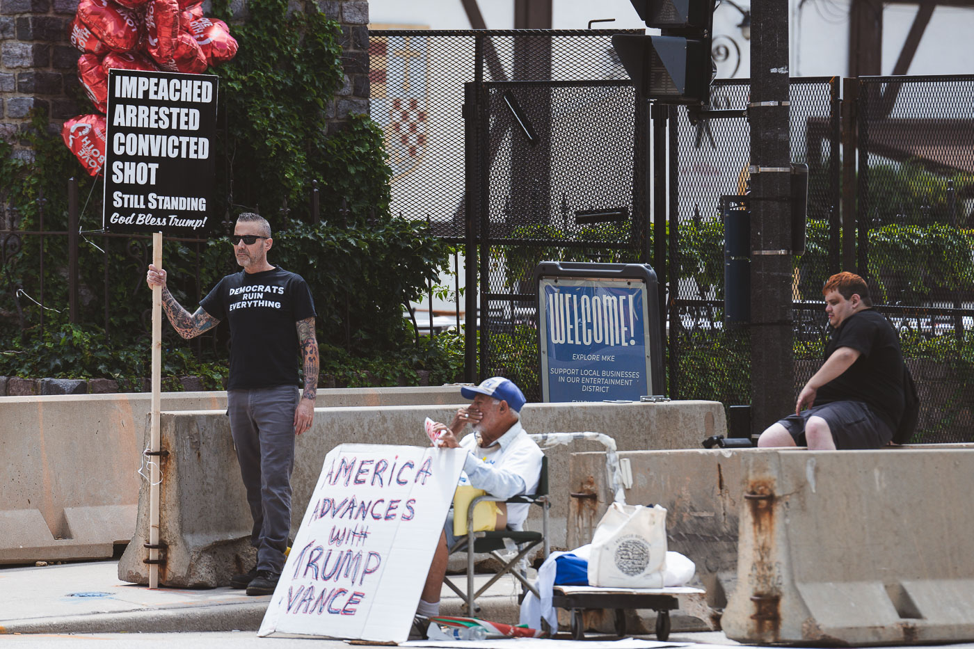 Supporters of Donald Trump hold up signs outside the entrance of the 2024 Republican National Convention,