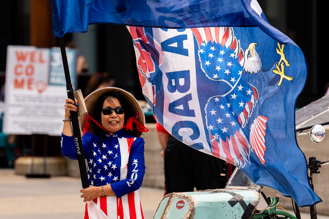 A woman dressed in American flag attire holds a Trump flag outside the 2024 Republican National Convention in Milwaukee.