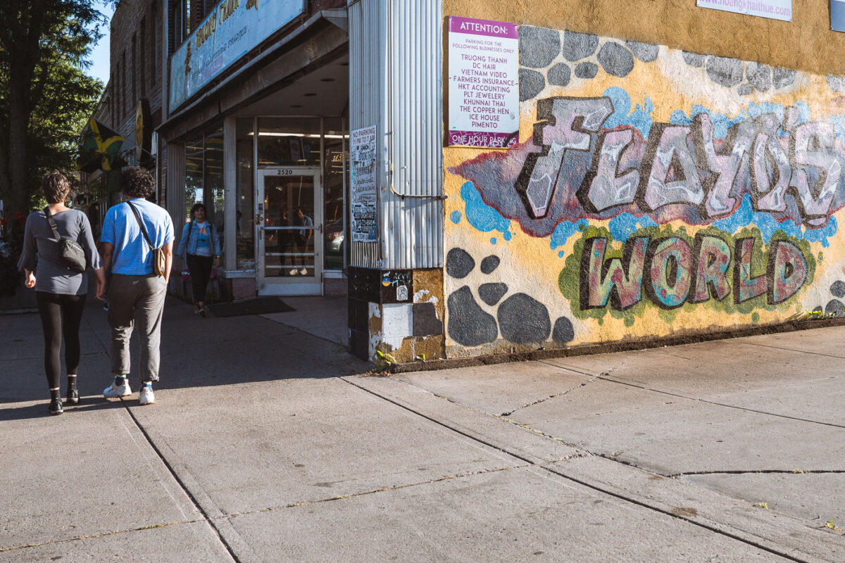 People walk by a Floyd's World mural on Nicollet Ave in Minneapolis.