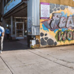 People walk by a Floyd's World mural on Nicollet Ave in Minneapolis.