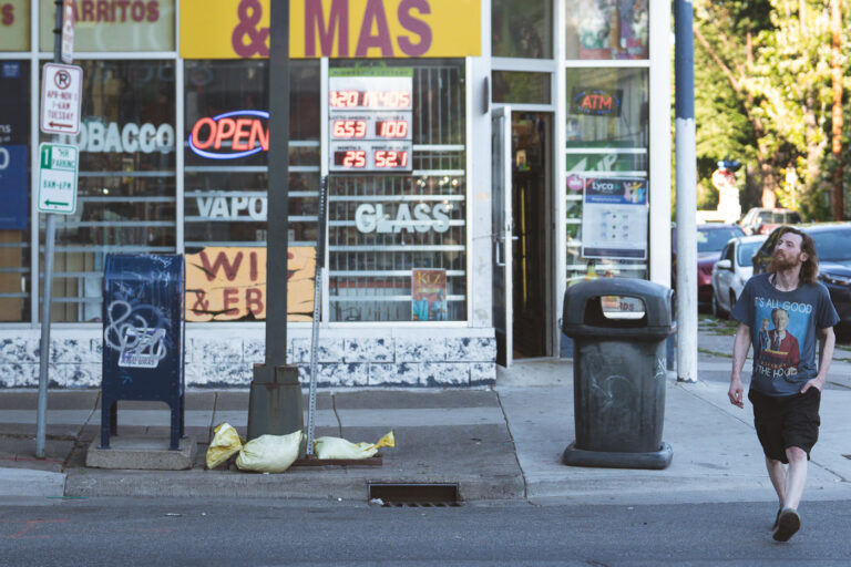 It's All Good 2 Man with a "It's All Good" shirt walks across Nicollet Ave in Minneapolis.