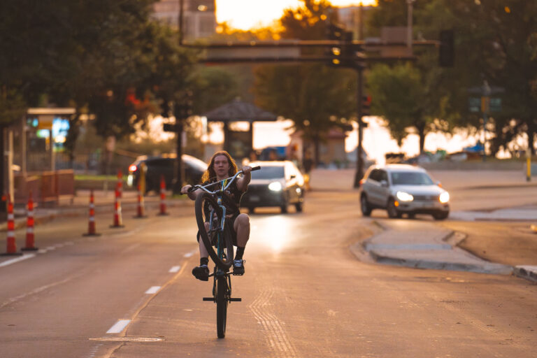 Biker on Lake Street doing a wheelie 4 Biker on Lake Street in Minneapolis also enjoying the last day of summer - on one wheel.