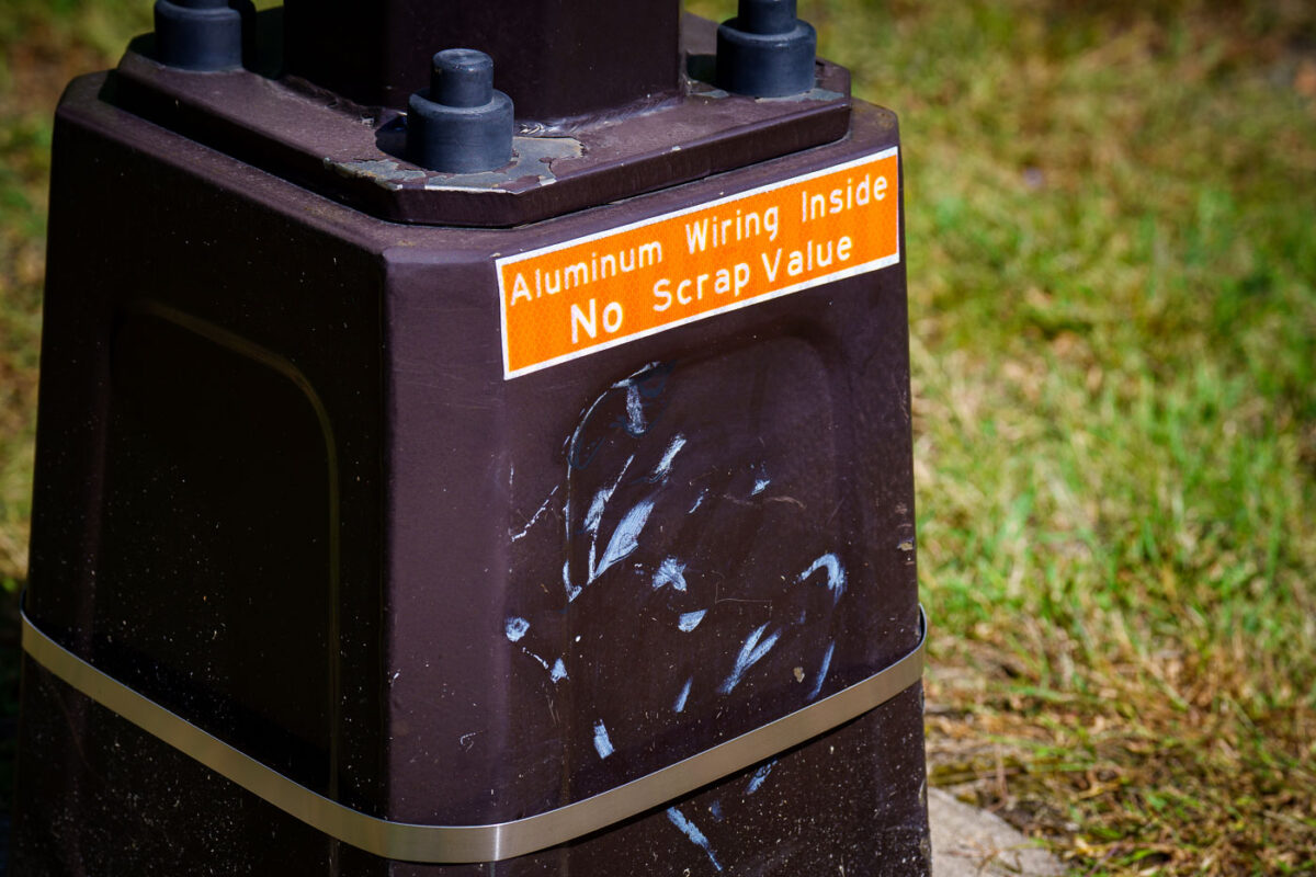 After light poles continue to be damaged by copper thieves, new LED lighting on a popular Minneapolis trail comes with a new reflective sign: "Aluminum Wiring Inside No Scrap Value".