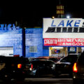 A Minneapolis police squad car drives down Lake Street in front of Lake St Autos.