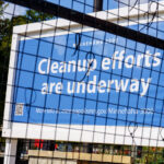 Signage at the former Minneapolis police third precinct police station proclaiming cleanup efforts underway. The building is being renovated into a voting center.