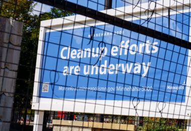 Signage at the former Minneapolis police third precinct police station proclaiming cleanup efforts underway. The building is being renovated into a voting center.