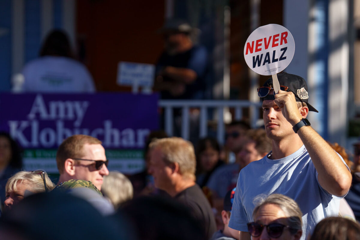 A man holds up a "Never Walz" sign on a stick at the Minnesota State Fair outside where Governor and Vice Presidential Candidate Tim Walz was going to make an appearance.