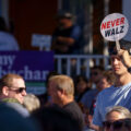 A man holds up a "Never Walz" sign on a stick at the Minnesota State Fair outside where Governor and Vice Presidential Candidate Tim Walz was going to make an appearance.