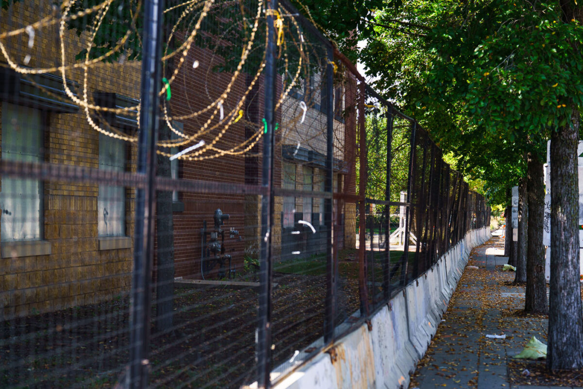 Razor wire and concrete barricades continue to surround the former Minneapolis police 3rd precinct police station. The station was burned by protesters in May 2020 and is being renovated into an community voting center.